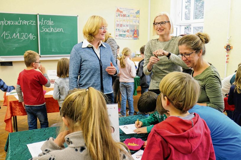 Landtagsabgeordnete Daniela Kuge (M.) erlebt mit allen Sinnen, wie Lebensmittel schmecken, aussehen, riechen oder sich anfühlen und beim Reinbeißen klingen. Gemeinsam mit der Verbraucherzentrale begleitet die Meißner Politikerin das Projekt in der Questenbergschule mit einer dritten Klasse. Foto: VZS