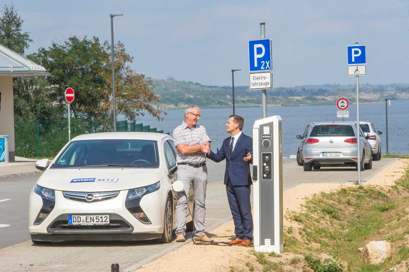 Schönau-Berzdorfs Bürgermeister Christian Hänel (links) mit Enso Netz- Regionalbereichsleiter Gunther Herzig an der neuen Ladesäule. Die steht direkt am Parkplatz der Blauen Lagune. Foto: ENSO/Weidler