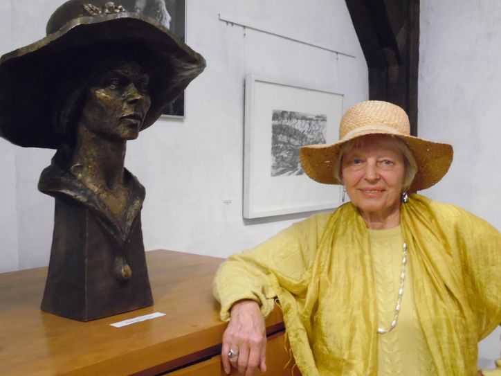 Helga Luzens neben "ihrer" Bronzeplastik, die Hermann Naumann schuf und in der aktuellen Ausstellung zu sehen ist. Foto: Wo