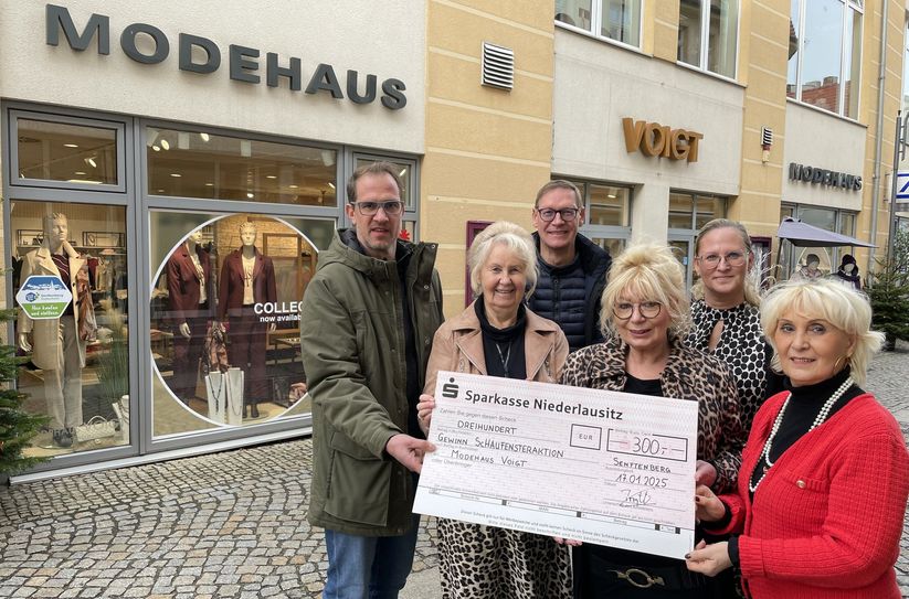Jan Przybilski (li.) hat den symbolischen Scheck an das Team vom Modehaus Voigt überreicht: Es freuen sich Ursula Voigt (2.v.li.), Steffen Voigt (3.v.li.), Mandy Haase (3.v.re.), Antje Voigt (2.v.re.) und Eveline Mielke (re.).