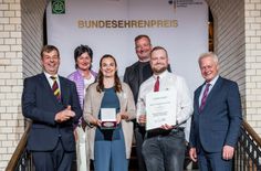 Bundesminister Alois Rainer (r.) überreichte gemeinsam mit DLG-Präsident Hubertus Paetow (l.) Urkunde und Medaille an Ludwig, Annett, Danilo und Sophie Dubau.