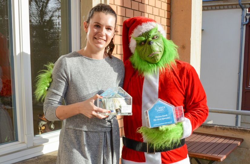 Diana Uhlemann vom Sonnenstrahl e.V. und der Grinch alias Daniel Skorka freuten sich über die hohe Spendensumme.
