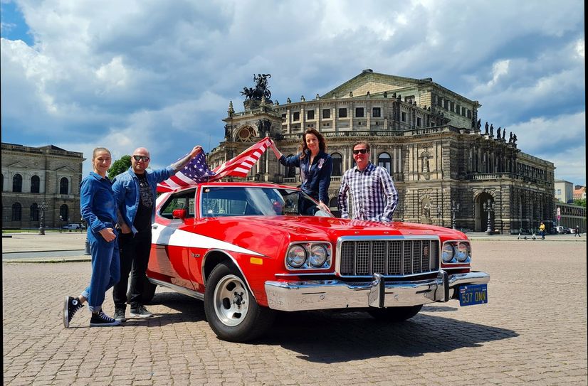 Die "Macher" der US Car Convention (v.l.) Stefanie Lemme, Mathias Lindner, Daniela Hesse und Matteo Böhme, mit einem Ford Grand Torino, Baujahr 1976, vor der Semperoper.