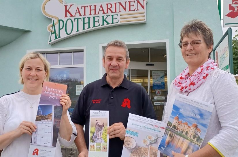 Ilka Kube (li), Wieland Krug und Varinia Ulrich (re)  stellen die neuen Kalender der drei Herzberger Apotheken vor.