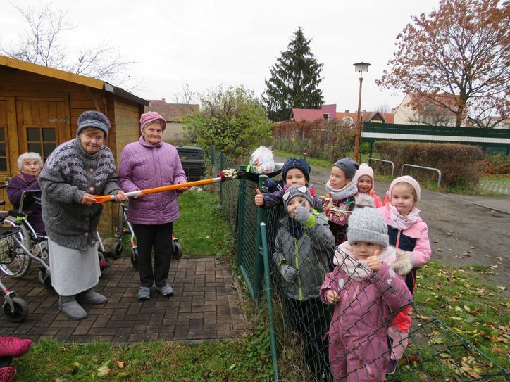 Corona macht kreativ. Mit einem Schneeschieber wurden kleine Geschenke übergeben. Was den beiden Generationen aber noch viel wichtiger war: Das Wiedersehen. Wenn auch nur am  Gartenzaun. Foto: Silke Richter