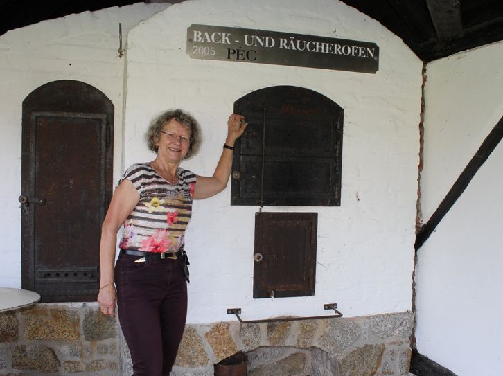 Die stellvertretende Vorsitzende des Heimat- und Kulturvereins der Gemeinde Nebelschütz, Karin Besser, am Back- und Räucherofen. Hier soll künftig wieder Pizza gebacken werden.