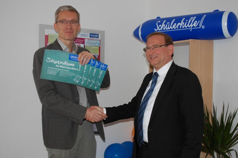 Frank Nichterlein  (li.) übergibt  Jürgen Opitz Gutscheine  für Nachhilfestunden für die fünf Schulen der Stadt.     Foto: Wo