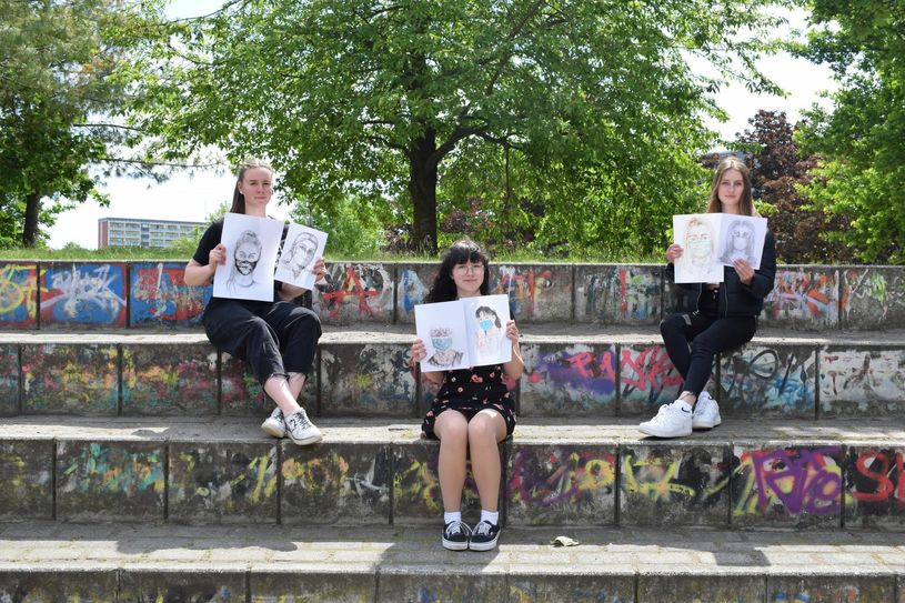 Betty Kulke, Theresa Kirchhübel und Lea Zihang präsentieren die in Heimarbeit entstandenen Selbstporträts mit Maske.                                                                                                                                                                                           Foto: asl