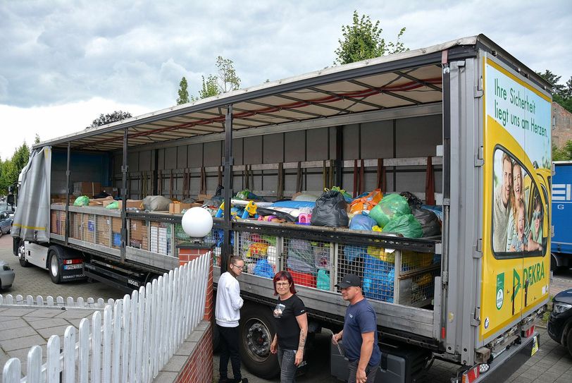 Julia Kraml, Silke Butzlaff und LKW-Fahrer Sven Weiß (v.l.) kurz vor der Abfahrt am beladenen LKW. Auch »Glück Auf«-Grüße in Form eines Schecks reisten an den Bürgermeister von Bedburg mit. Foto: Detlef Bogott