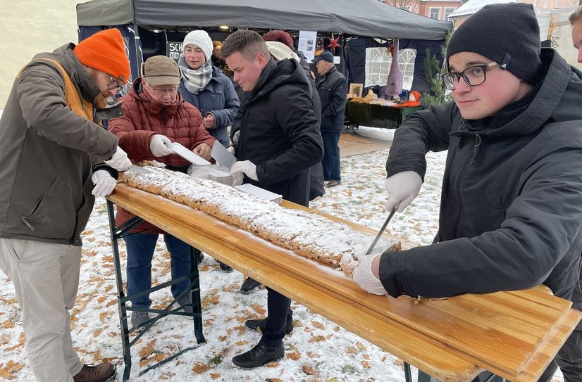 Stollenanschnitt beim ersten Weihnachtsmarkt der Vereine an der Kirche in Ruhland mit Bürgermeister Thomas Höntsch (re.) und Pfarrer Karl Naumann (li.).