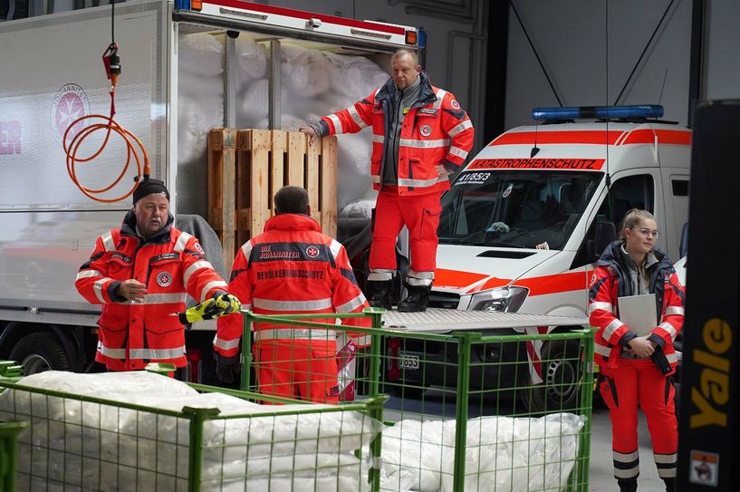 Johanniter packen Hilfslieferungen für die Ukraine zusammen.