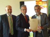 Burg im Spreewald ist Thermalsoleheilbad: Brandenburgs Gesundheitsstaatssekretär Patrick Wahl (m.) überreicht die Urkunde an Bürgermeister Bernd Ragotzky (r.) und Amtsdirektor Tobias Hentschel (l.).