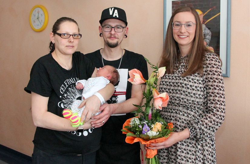 Geschäftsführerin Juliane Kirfe (r.) gratuliert Familie Ryll zur Geburt von Tochter Mia-Sophie.