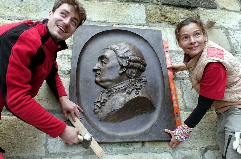 Diplom Bildhauerin und Steinmetz Anne Kajer (45) aus Berggießhübel und Leonhard Hagedorn (24) aus Dresden, Steinmetz-Geselle vom Steinmetzbetrieb Kajer in der Kurstadt Berggießhübel, bringen das 60 Kilogramm schwere Relief an einer Mauer der Festung Sonnenstein an.