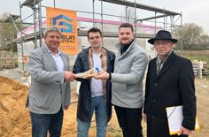Oberbürgermeister Prof. Dr. Holm Große (l.) und Andreas Wendler von der Wohnungswirtschaft und Bau GmbH Bischofswerda (r.) begrüßen Adrian und Christoph Richter  in Bischofswerda.