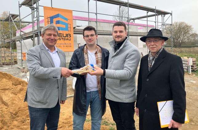 Oberbürgermeister Prof. Dr. Holm Große (l.) und Andreas Wendler von der Wohnungswirtschaft und Bau GmbH Bischofswerda (r.) begrüßen Adrian und Christoph Richter  in Bischofswerda.