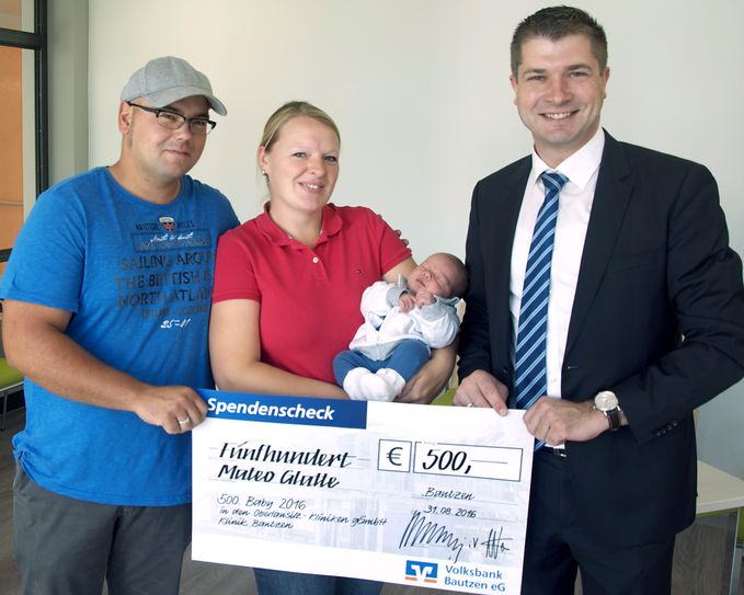 Andreas Wanitzek von der Volksbank Bautzen ist der Gratulant und überraschte die Eltern mit einem Scheck in Höhe von 500 Euro. Foto: Oberlausitz-Kliniken gGmbH