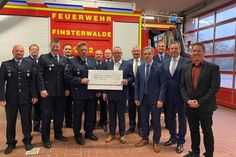 Stadtbrandmeister Michael Kamenz nimmt stellvertretend für die Freiwillige Feuerwehr Finsterwalde den Scheck von Innenminister Michael Stübgen entgegen.