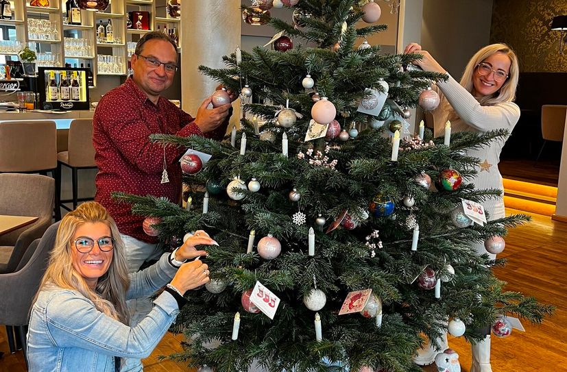Carolin Rühle-Marten (Luisenhof Dresden), Frank Hendrich (Kinder- und Jugendhilfeverbund Freital e.V.) und Nancy Naumann (love it. again) schmücken den Wunschbaum.