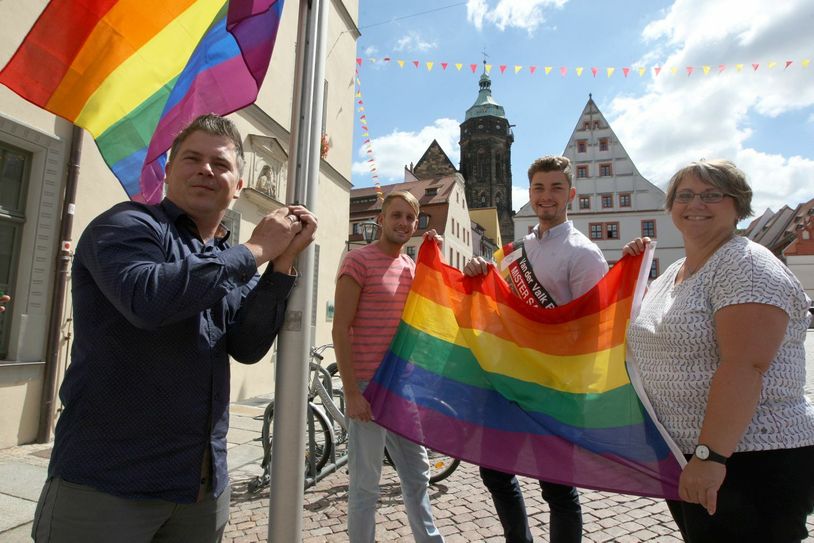 Sie beflaggten das Rathaus: Horst Bock aus Struppen (CSD Pirna e.V., Christian Hesse (CSD Pirna e.V.), Philipp Schneider (amtierender Mister Sachsen) sowie Sandra Wels (Gleichstellungsbeauftragte der Stadt Pirna). Foto: Daniel Förster