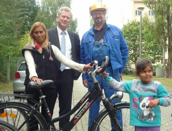 Kraftwerksleiter Thomas Hörtinger (2.v.l.) und Betriebsratsmitglied Winfried Kotte übergaben am Mittwoch sieben Fahrräder aus Mitarbeiterspenden an Familien aus der Gemeinschaftsunterkunft in Boxberg, wie hier an Frau Auti und Tochter Tina aus Serbien. Foto: Vattenfall