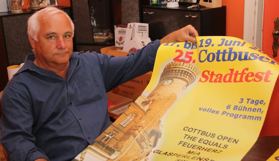 Eberhard Heieck, Chef der Agentur COEX, mit dem offiziellen Plakat zum 25. Cottbuser Stadtfest. Sein Unternehmen ist u.a. auch für das Programnm des Peitzer Fischerfestes (dieses Jahr: 12. bis 15. August) und den Weihnachtsmarkt Cottbus zuständig. Foto: jho