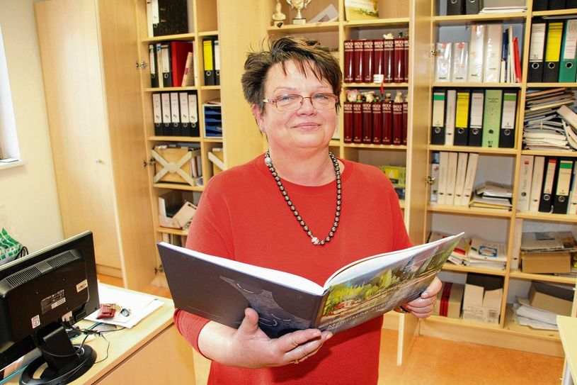Regine Pursian hat ihre Materialien aus den Schränken geräumt. Hier schaut sie in „Malerische Streifzüge um den SeeCampus“, Aquarelle von Bernhard Vogel. Foto: sts