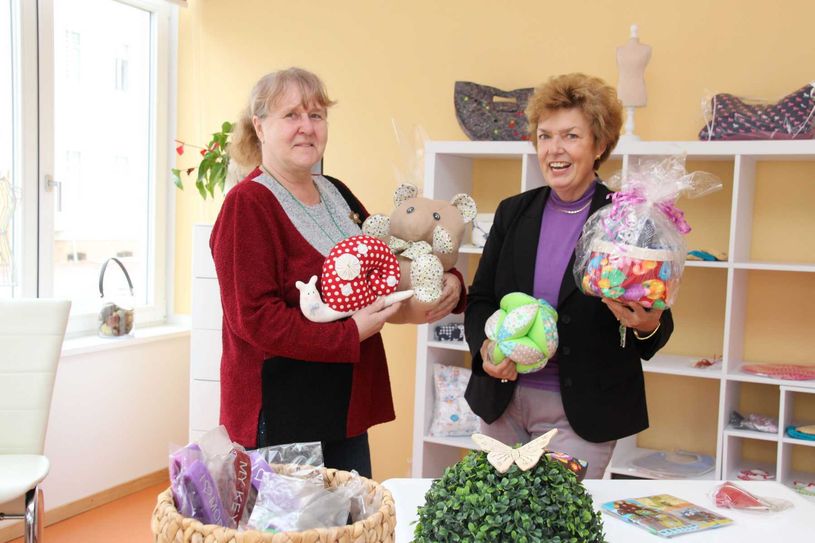 Hausleiterin Claudia Trojan (re.) und Monika Uthe zeigen einige Handarbeitsartikel, die für einen schmalen Taler im Info-Eck des Beratungszentrums erworben werden können. Foto: jho