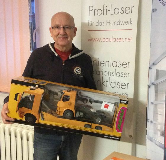 Uwe Dallmann von der Baulaser NET Handels GmbH aus Nossen verschenkt Trucks an Kinder. Foto: WochenKurier