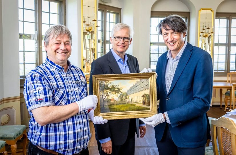 Andrej Pawluschkow (wissenschaftlicher Mitarbeiter Festung Königstein, li.) und André Thieme (Geschäftsführer Festung Königstein, re.) nahmen von Christoph Großpietsch (Enkel des Sammlers Fritz Busche, Mitte) das wertvolle Gemälde entgegen.