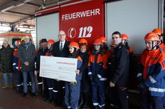 Ministerpräsident Dietmar Woidke überreicht den symbolischen Scheck an Robert Buder, Vorstandsvorsitzender des Kreisfeuerwehrverbandes, und die Jugendlichen, die am Wahlpflichtfach teilnehmen.