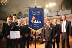 Stadtwehrleiter Robert Gudat und die Stadtteilwehrleiter vor der neuen Fahne - rechts OB Marco Müller, hinten ((halb verdeckt) Frank Ricklin vom Kreisfeuerwehrverband.