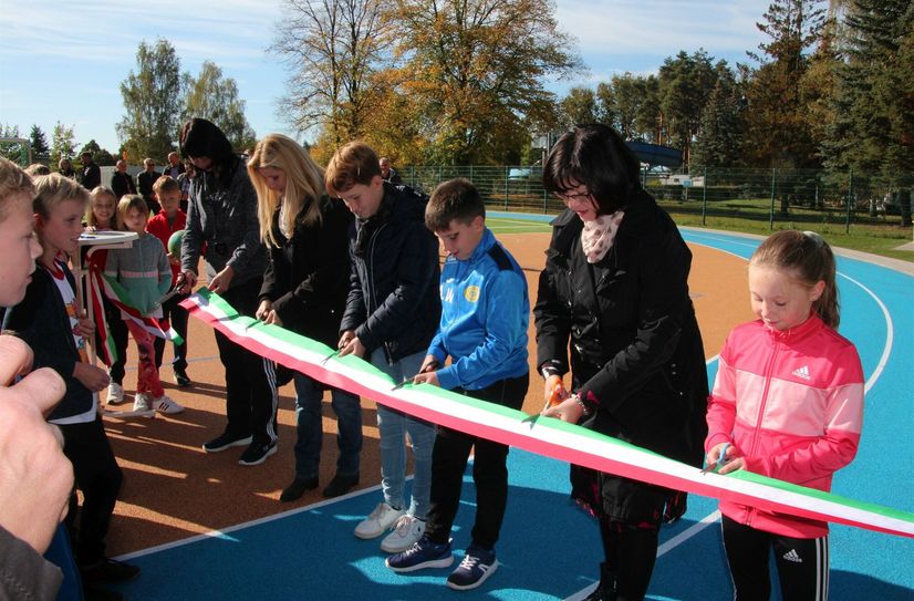 Gemeinsam mit Schülern und Pädagogen der Grundschule Geschwister Scholl schneidet Bürgermeisterin Christine Herntier das Band für die neue Sportanlage durch.