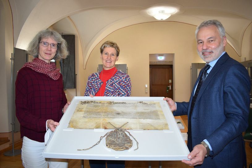 v.l.n.r.: Dr. Ursula Hartwieg (KEK), Grit Richter-Laugwitz (Archivverbund), Dr. Michael Vogel (SLUB) mit einer Urkunde von Kaiser Rudolf II. aus dem Jahr 1585. Foto: spa