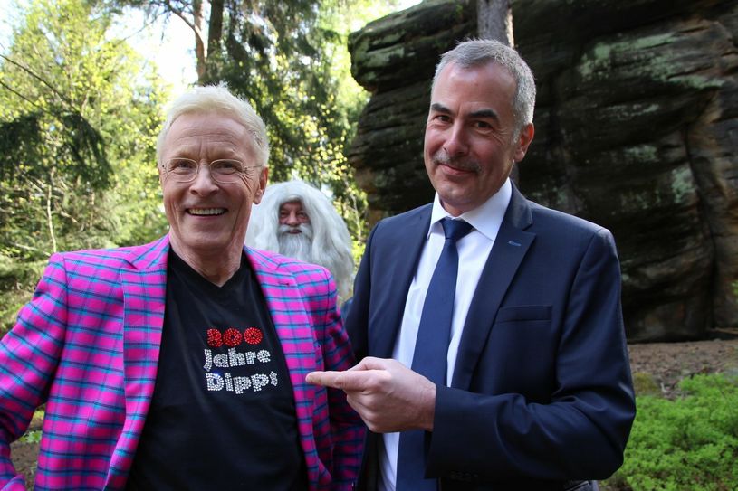 Wolle da, Dippold da und Wald gibt´s auch. Besser geht´s nicht: Wolfgang »Wolle« Förster und Oberbürgermeister Jens Peter (r.) rühren die Werbetrommel fürs erste Juniwochenende. Im Hintergrund stiefelt Namenspatron Dippold herum.  Zu sehen ist auch sein Habitat, der Einsiedlerfelsen. Foto: Schramm
