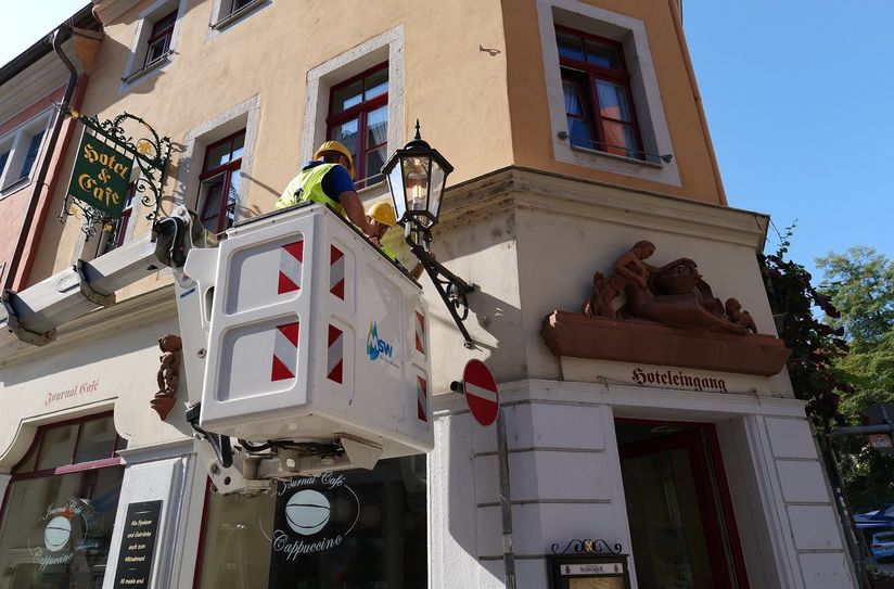 Mitarbeiter der Meißner Stadtwerke installieren auf der Fleischergasse die neuen LED-Leuchtmittel.
