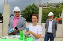 Lausitzbadchef Matthias Brauer, Mitarbeiterin Janett Schreiber und SWH-Geschäftsführer Thomas Bleier füllten die Zeitkapsel, bevor sie für die Zukunft einbetoniert wurde.