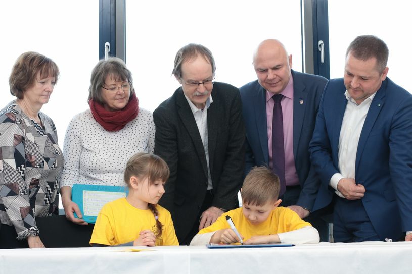 Für die beiden Erstklässler Laura Kühne und Johann Krause war die erste Vertragsunterzeichnung ein besonderer Moment. Beobachtet und unterstützt wurden sie dabei (v.l.) von der Rektorin Gabriele Wickmann, Klassenlehrerin Kerstin Kießling, LWG-Geschäftsführer Reinhard Beer, Umweltdezernent Thomas Bergner und LWG-Geschäftsführer Marten Eger Foto: Spree PR/ Petsch