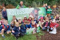 Begeisterte Kinder weihen beim Verein LebNatEne e.V. in der puren Natur das neue Vereinsschild ein.
