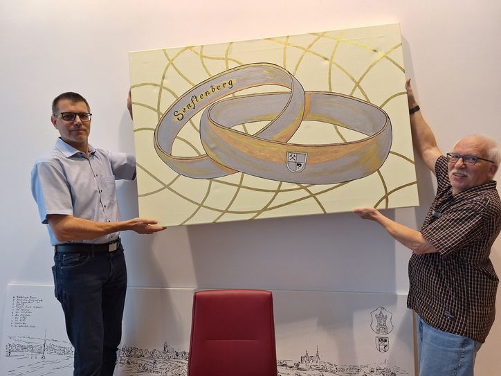 Das Ölbild »Die Ehe ist Raum und Zeit« wurde gleich nach der Übergabe vom Künstler Heinz-Christian Hübner (r.) und  Amtsleiter André Nickel aufgehangen.