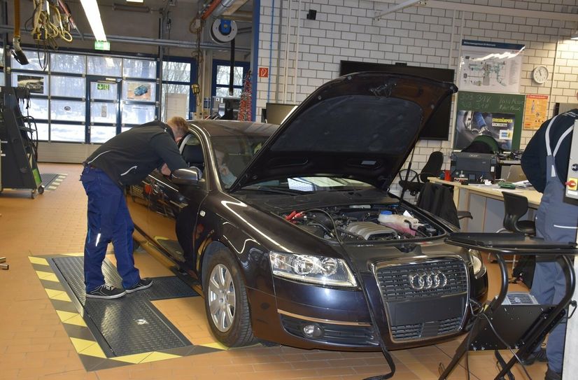 Auszubildende des dritten Lehrjahres suchen im Auto nach eingebauten Fehlern.