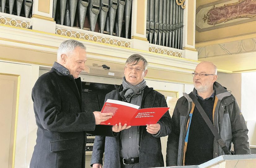 Sparkassenvorstand Rainer Schikatzki (li.) übergibt die Fördermittelzusage an Kirchenmusikdirektor Sebastian Schwarze-Wunderlich.