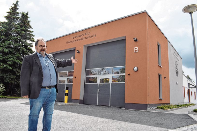 Bürgermeister Hardy Glausch zeigt auf das neue Gerätehaus der Klixer Wehr.