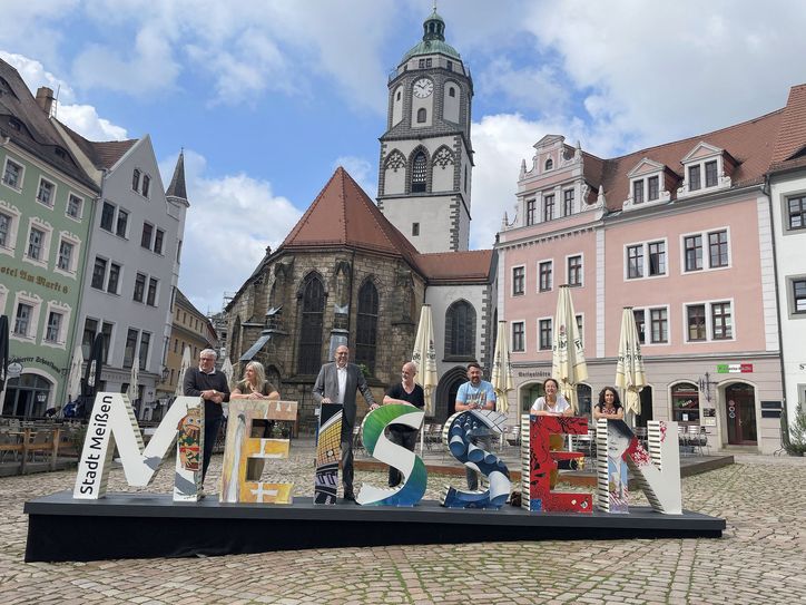 Oberbürgermeister Olaf Raschke (3.v.l.) und Stadtmarketing-Chef Christian Friedel (3.v.r.) haben gemeinsam mit den Künstlern, die die einzelnen Buchstaben gestaltet haben, Meißens ersten Selfie-Point auf dem Marktplatz eingeweiht. Dort wird er vorerst bis nach dem Weinfest stehen bleiben.