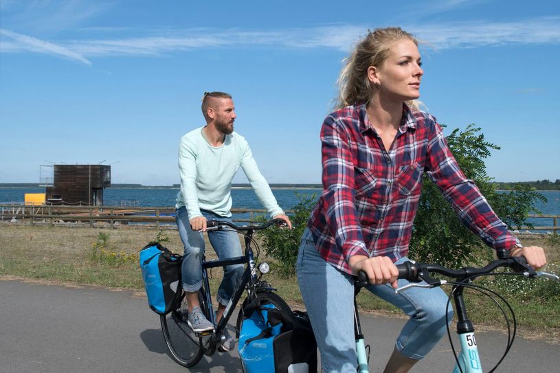 Radfahrer am Partwitzer See am schwimmenden Haus. Foto: Tourismusverband Lausitzer Seenland/Nada Quenzel