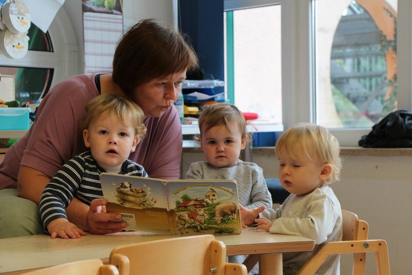 Mit Florian, Mylaina und Caitlin schaut sich Anja Scherf, Assistenzkraft in der Kita „Weinbergwichtel“ ein Buch an.                                                                                Foto: Lindackers