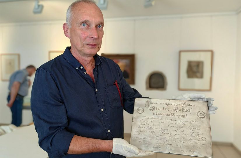 Alexander Lange, Chef der Stadtgalerie, zeigt eine Silberplatte, die von Schuch von Sängern geschenkt bekam. Außerdem zu sehen: eine Schale von 1912 zum 40. Dienstjubiläum, geschenkt  vom Orchester mit sämtlichen Unterschriften im Fuß der Schale und allen Ur- und Erstaufführungen eingraviert.