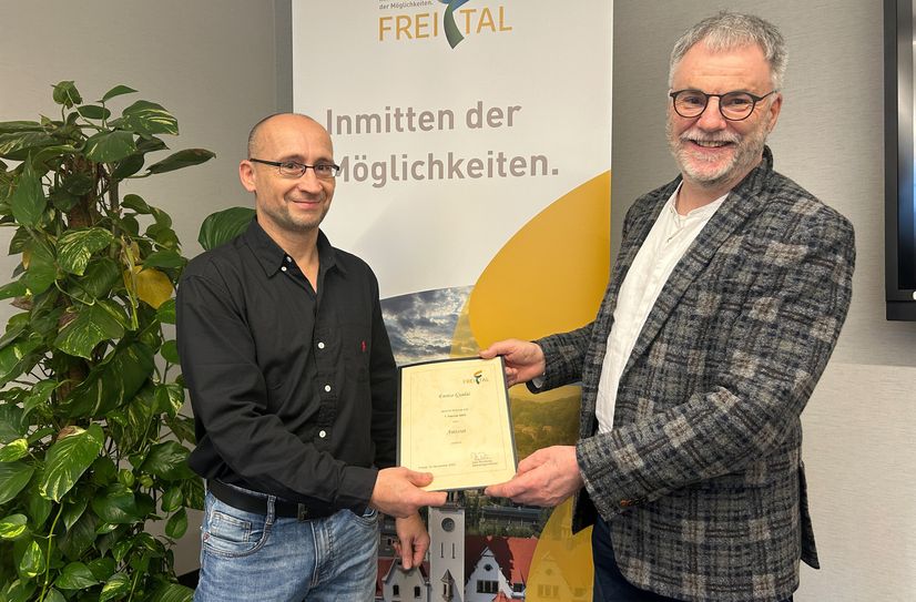 Oberbürgermeister Uwe Rumberg (re.) übergibt die Ernennungsurkunde an Enrico Gyulai.