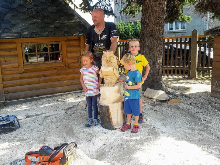 Künstler Mario Hennig aus Eibau arbeitete gemeinsam mit den Kita-Kindern an der neuen Lesebank. Foto: Glathe