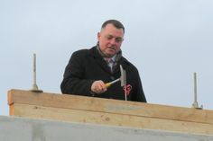 Landrat Udo Witschas beim Einschlagen des letzen Nagels während des Richtfestes. Foto: Matthias Stark